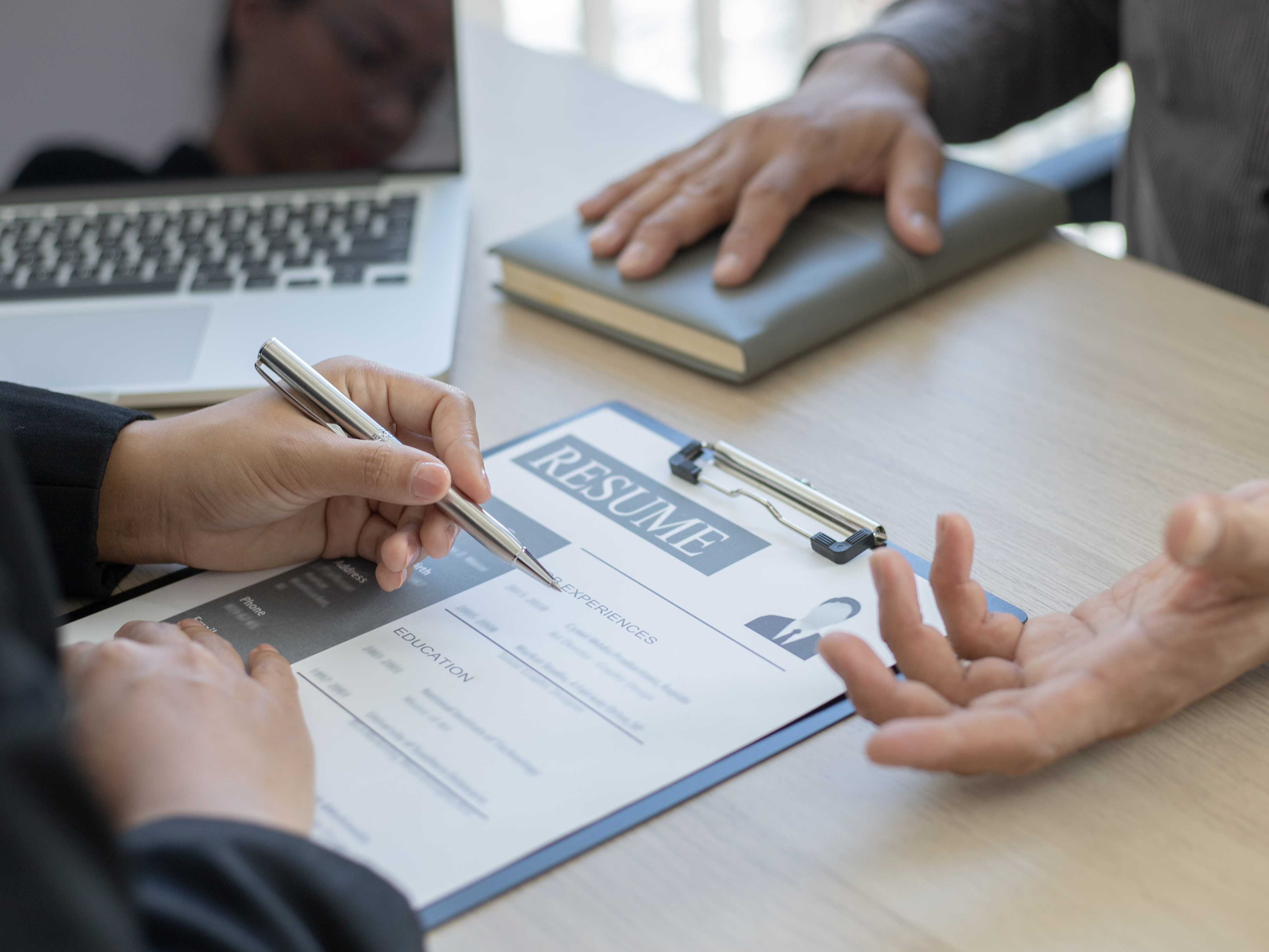 interviewer looking through candidates CV to show tips for choosing the right bespoke staffing solutions