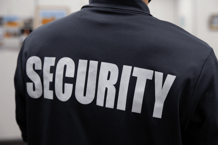 A member of security at work with uniform on that indicates his role 
