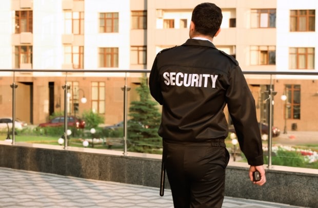 A hospital is protected by a member of security personnel who looks for any issues outside. 