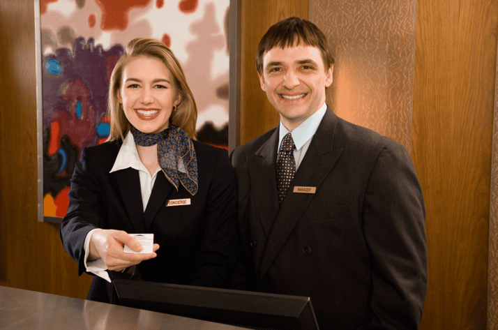 A concierge with her manager, providing great customer service, showing why you should hire a concierge.