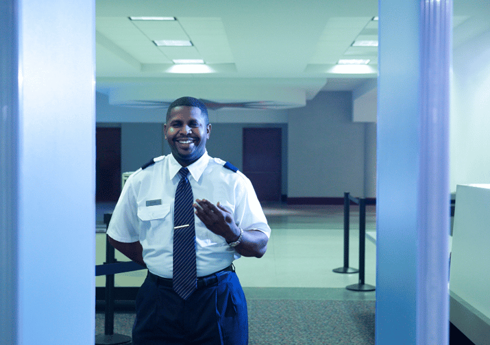 A smiling security officer who is taking pride in their work. 