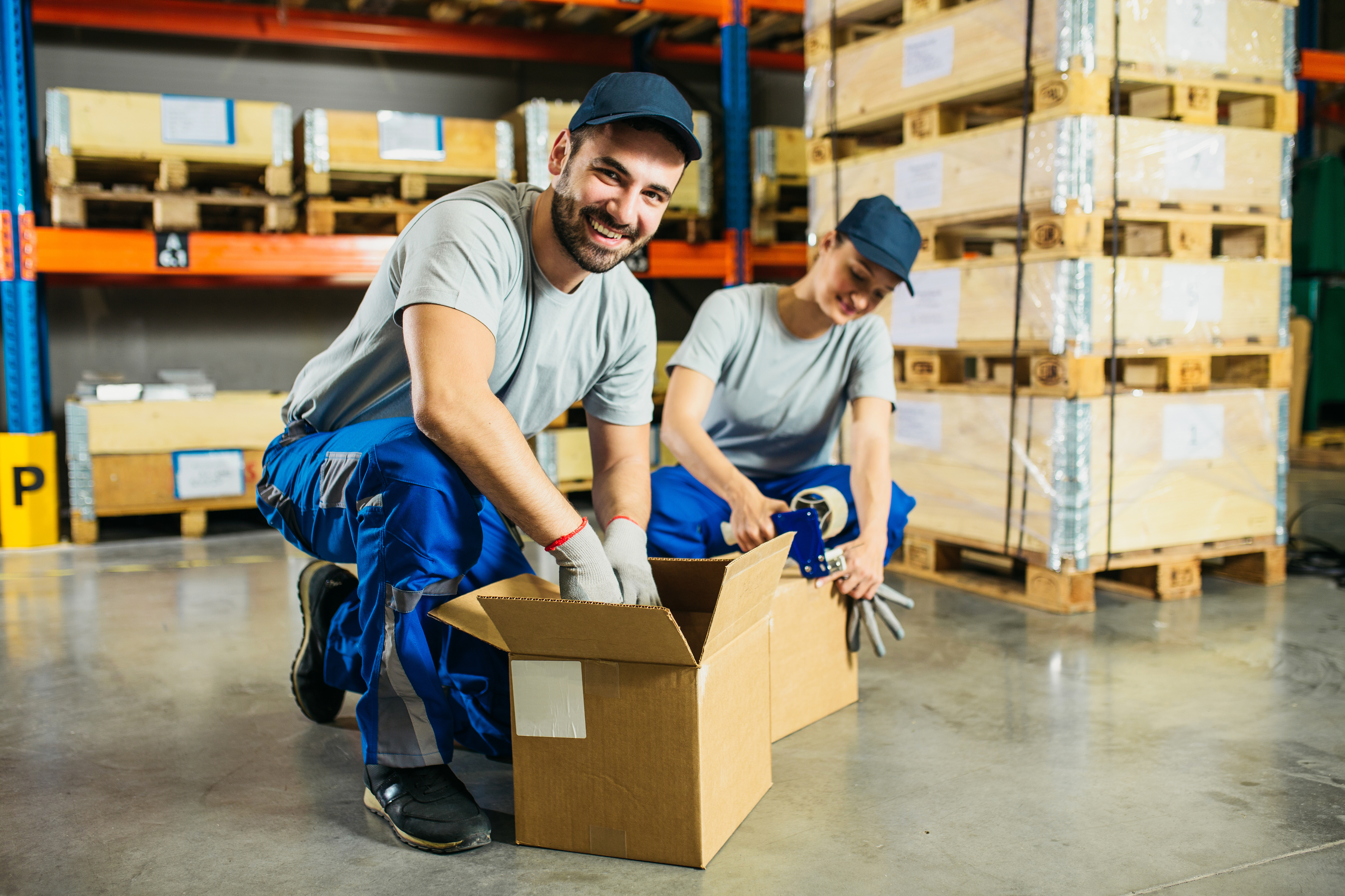 People smiling as they’re working in a horticultural packing warehouse. 