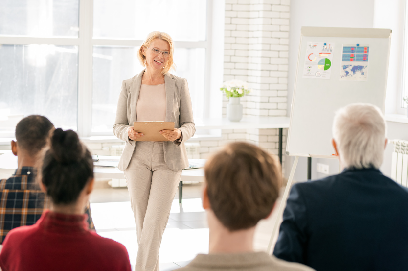 female tutor leading a training session to four work colleagues to show the types of employee training programmes to elevate team performance
