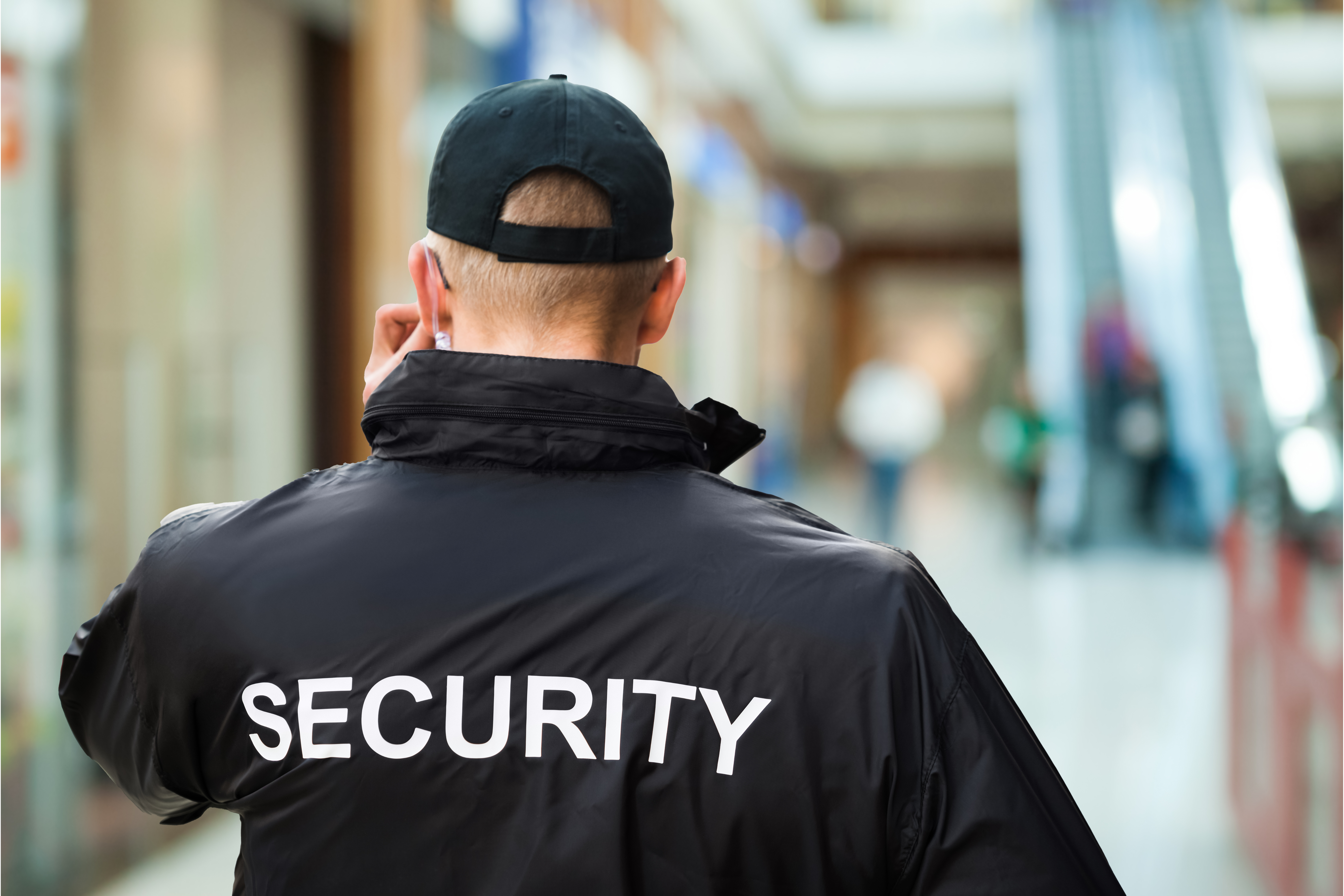 A security guard assesses the situation outside of a retail store that he is protecting.