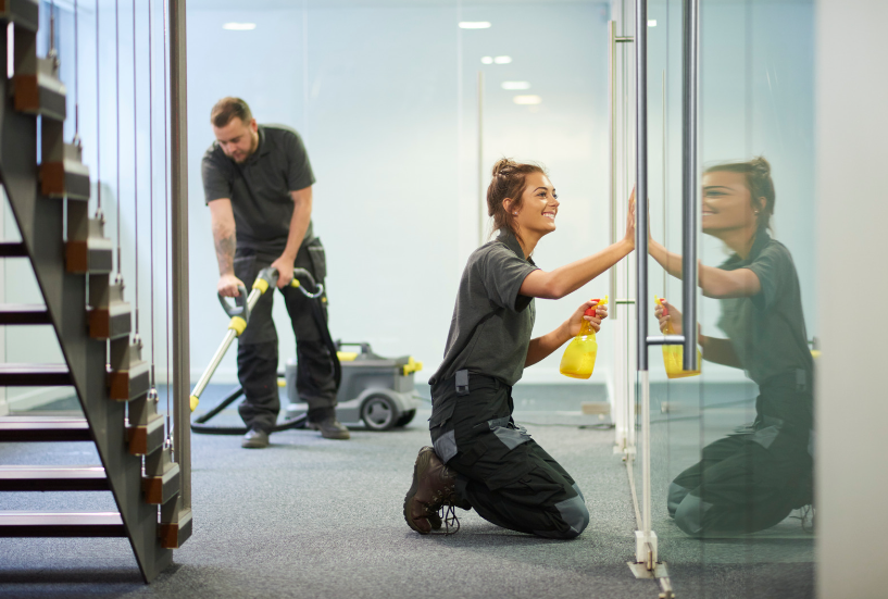 Two cleaners cleaning a commercial area to show the benefits of hiring an outsourced cleaning service.